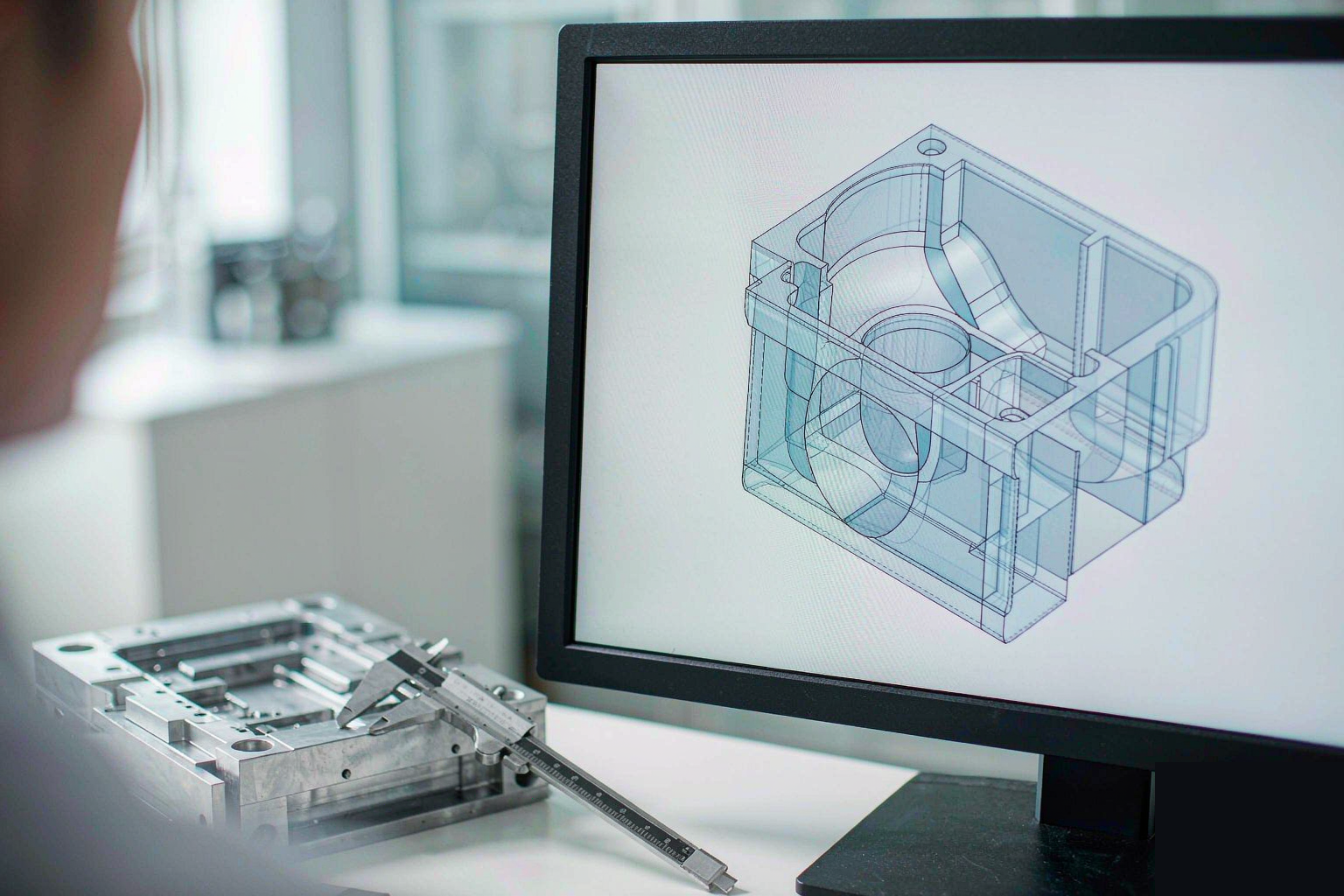 Design engineer reviewing a 3D CAD model of an injection molded plastic part with uniform wall thickness, ribs and draft angles