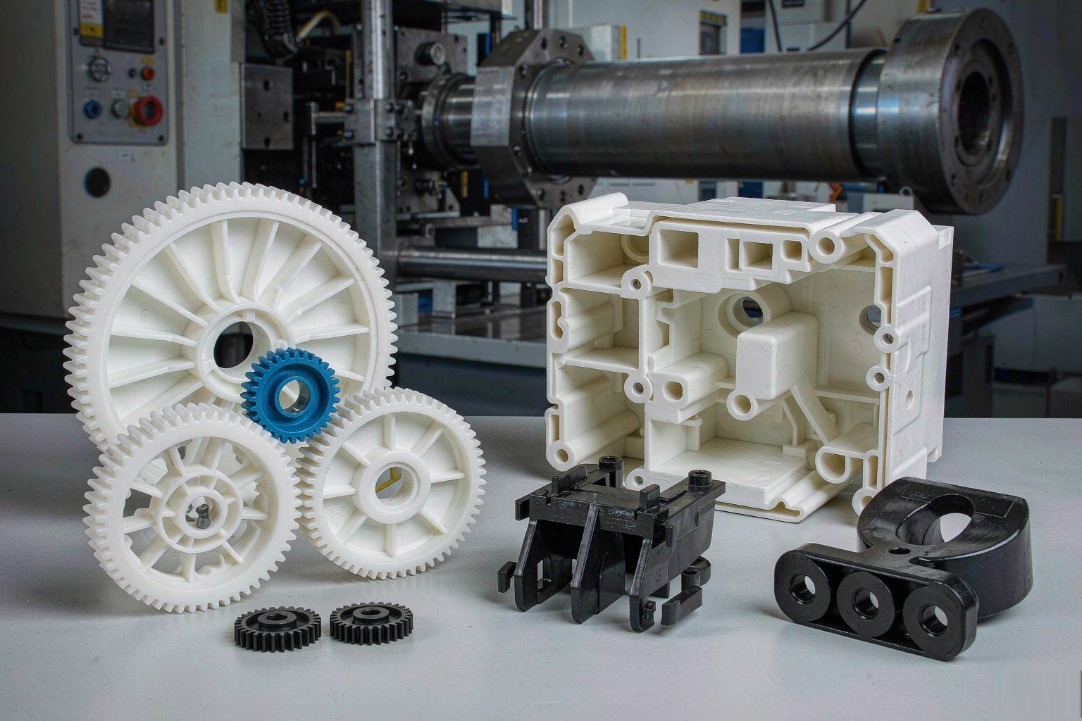 Custom injection molded plastic parts: gears, housings, connectors and brackets arranged on a workbench